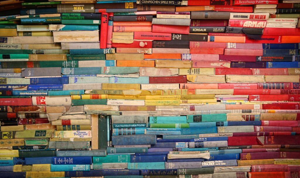 Wall of books showing spines in different colors, including blues, reds, and yellows.